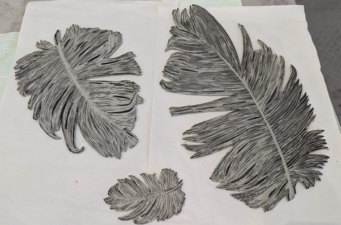 Three sizes of lino cut feathers