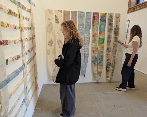 Visitors viewing the hanging swags and stitched calico strips at the Summer Show